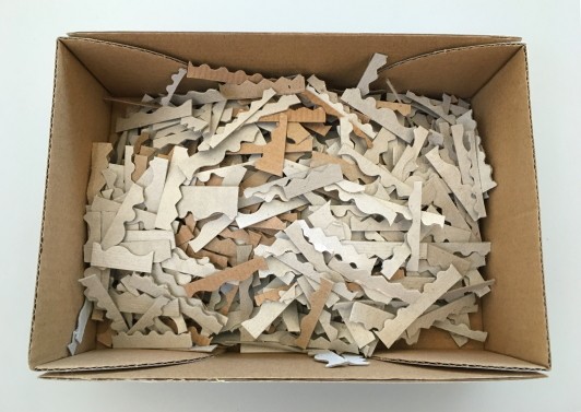A box filled with small cardboard pieces with shaped edges.