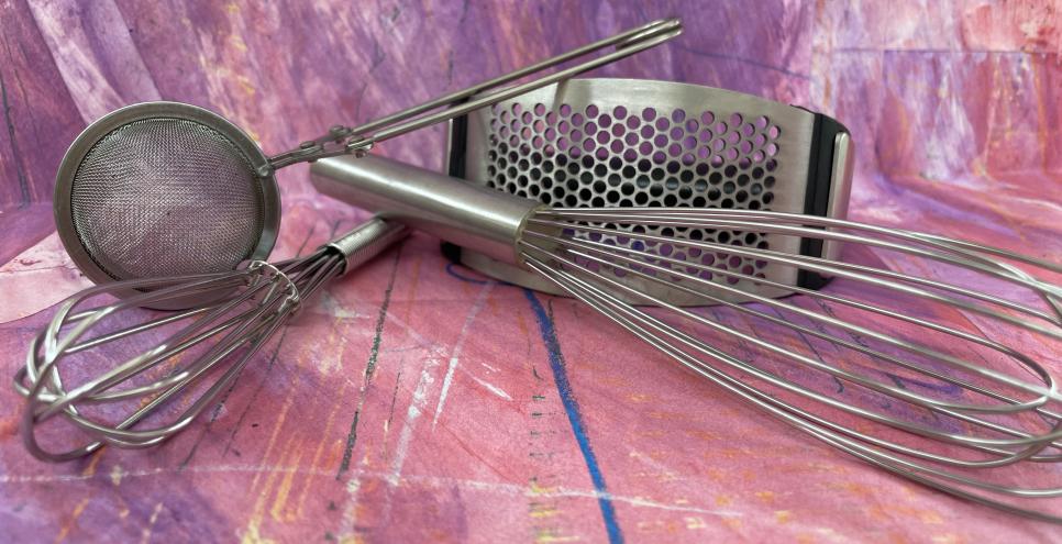 Several kitchen utensils on a collage painted paper