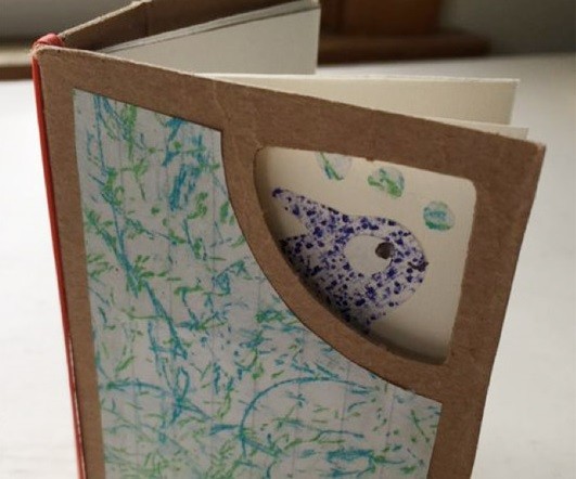 Book with cardboard cover that has a window cut out in the corner so you can see part of a fish on the first page of the bok.