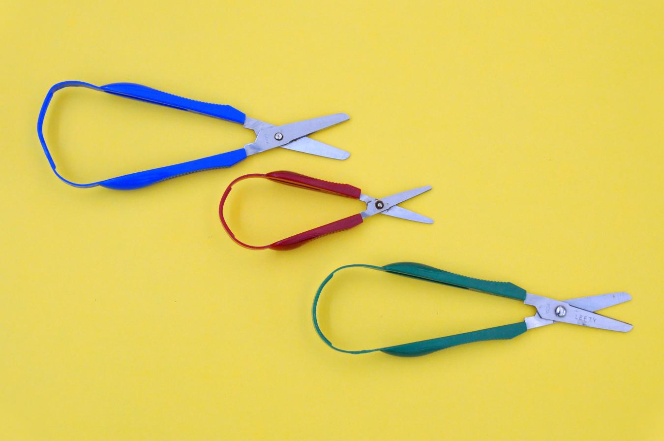 Three loop scissors with handles that are attached together in one continuous loop of plastic.