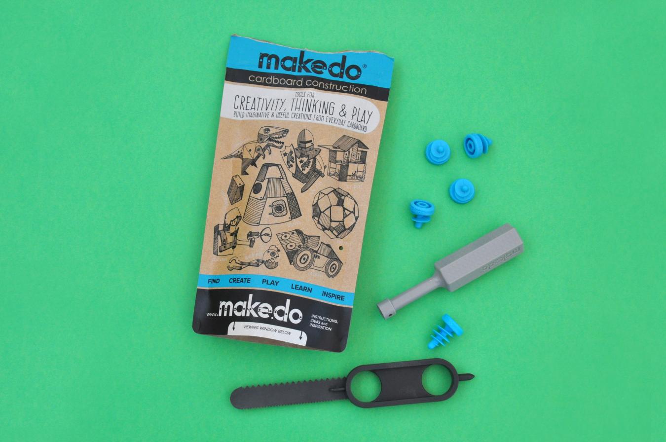 The Make-do cardboard kit with a plastic saw, screwdriver, and screws.