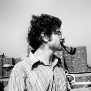 Arnold Lobel smoking a pipe on a city rooftop. 