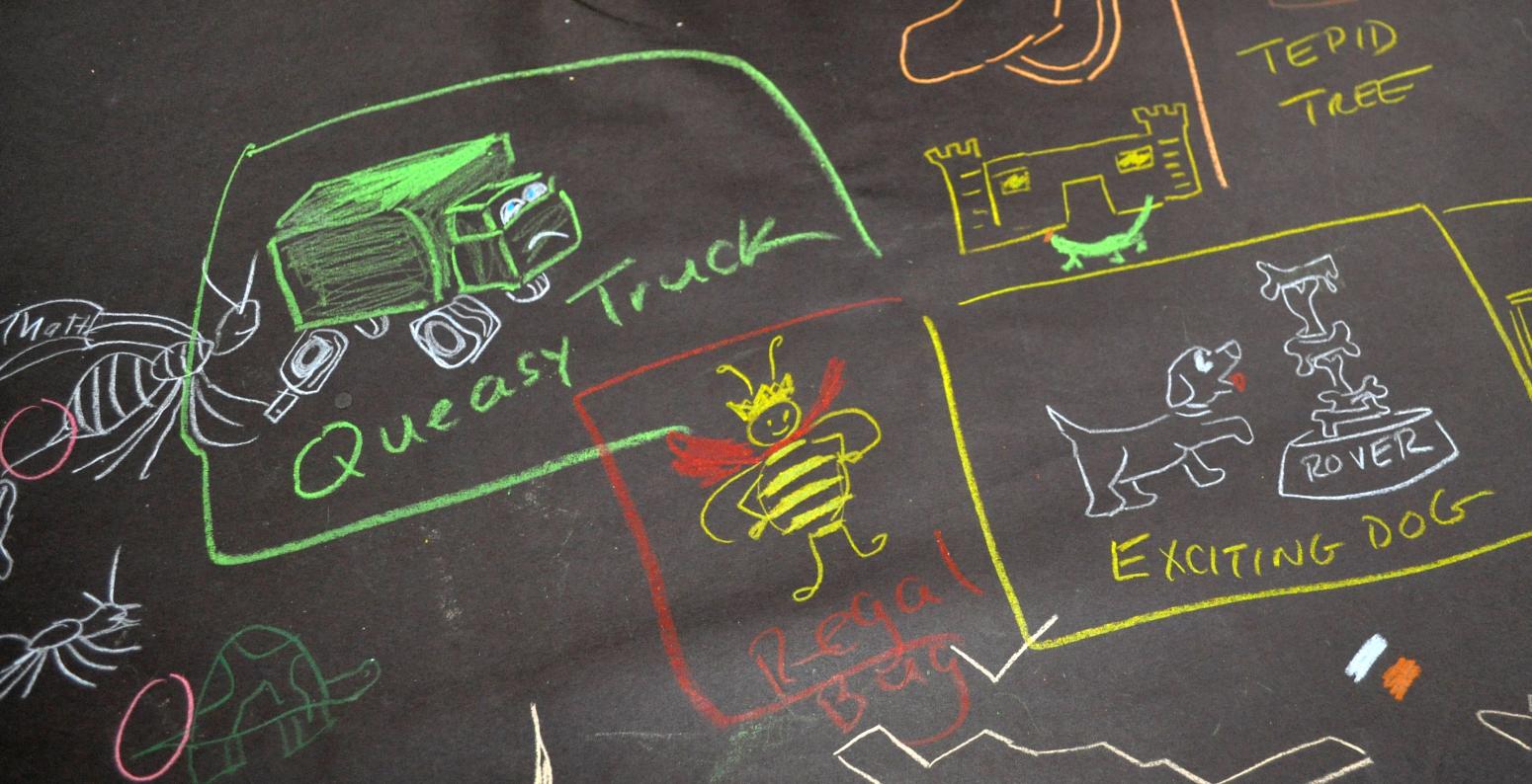 Drawings on black table covers including a queasy truck, tepid tree, elegant museum, and regal bug. 