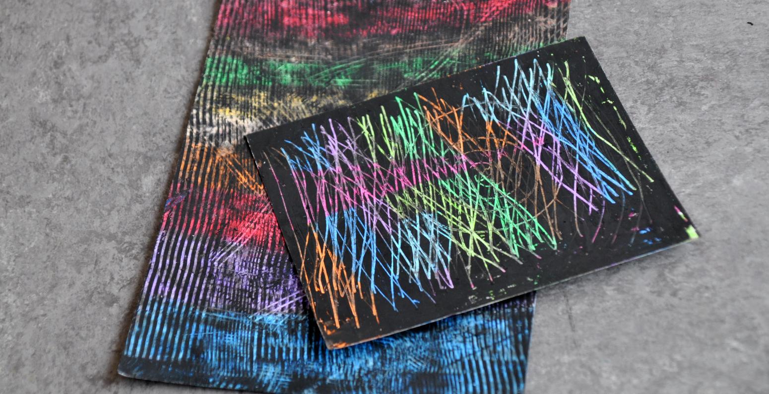 Two colorful oil pastel scratch boards with abstract lines scratched into them.