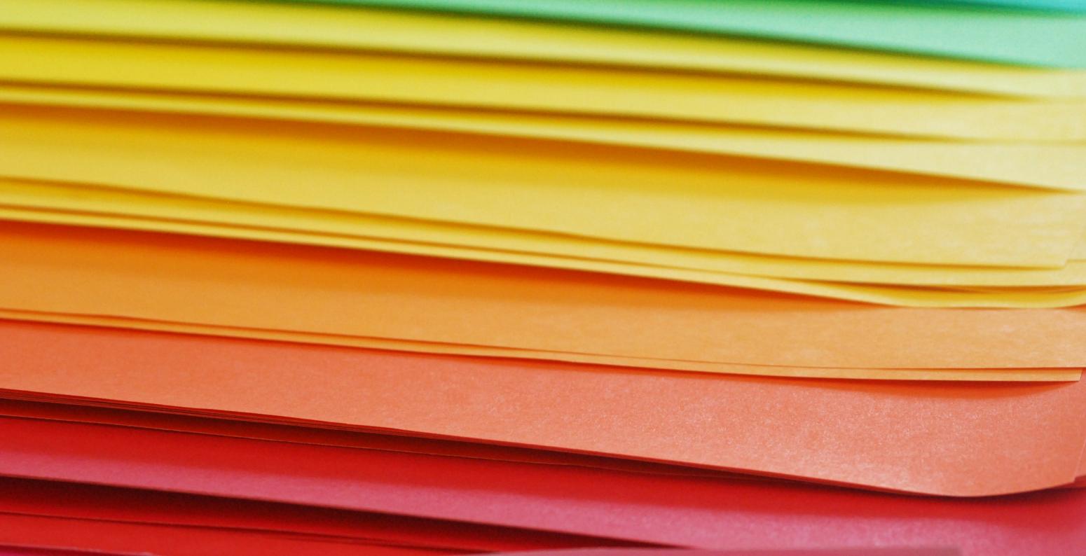 An array of colorful papers arranged in rainbow order.