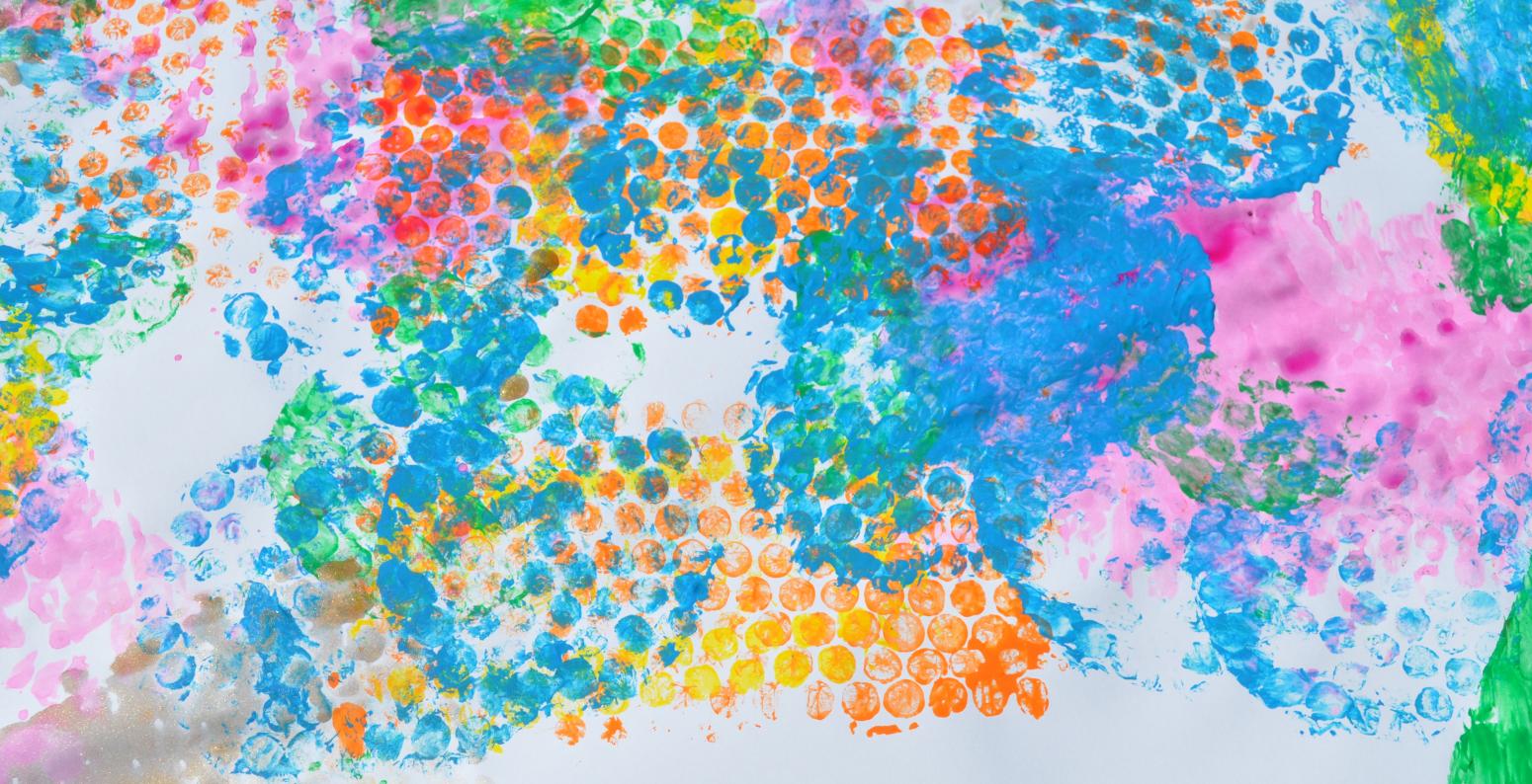 A white paper covered in colorful, bubble-wrap-stamp imprints.