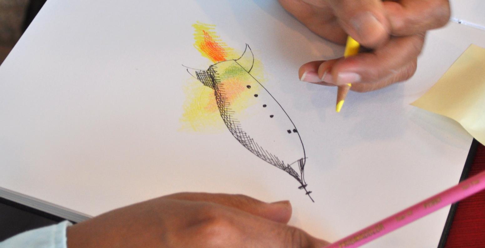 Author/illustrator Raúl Colón drawing a rocketship using colored pencils and a Sharpie.