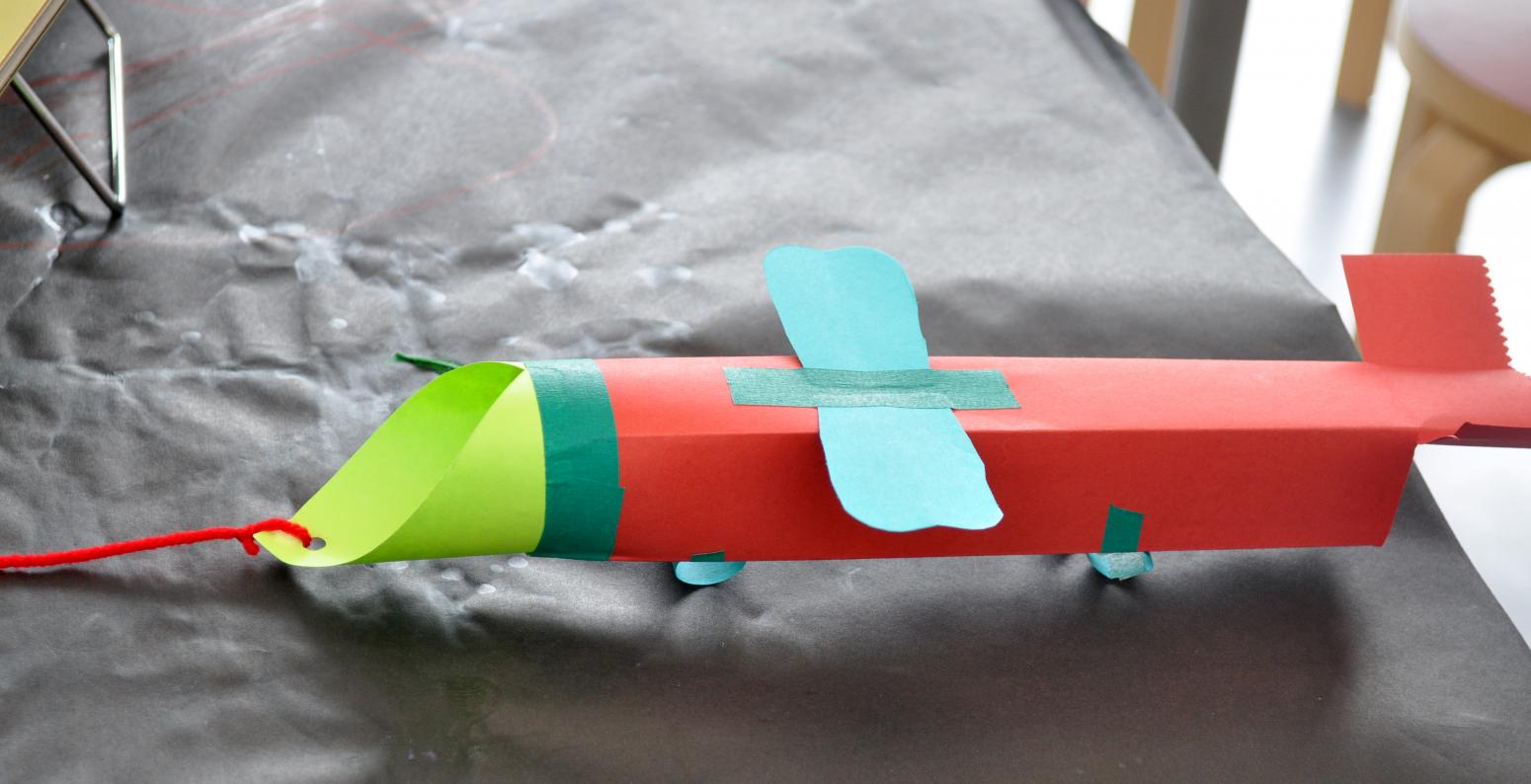 A sculpture of an airplane made out of red, green, and blue construction paper.