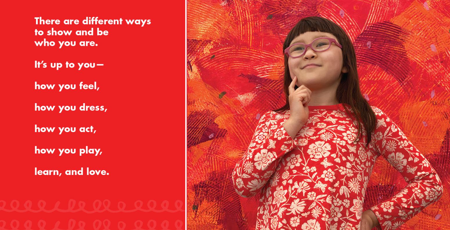 Young girl in red and white floral shirt stading in front of a red mural.