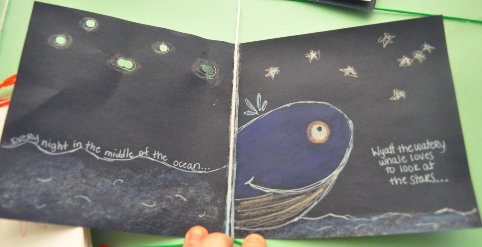 A book with a drawn whale named Wyatt who is looking out into a night sky with stars.