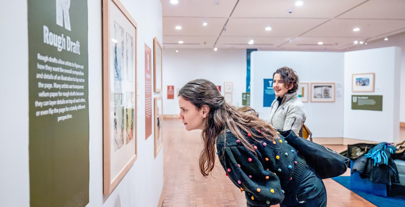 Two Museum guests look at art.