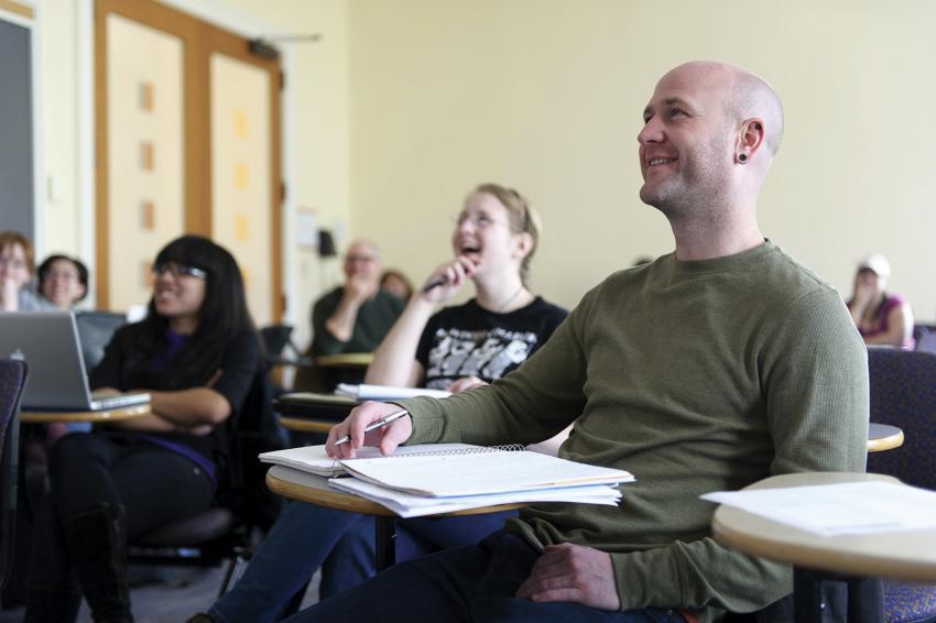 Simmons student laughing in lecture. 