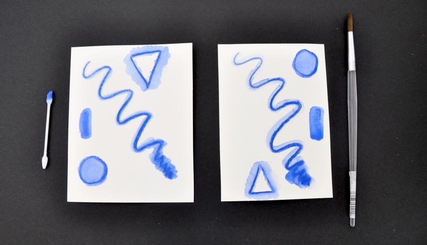 Two testing papers with a blue Stabilo, one where a cotton swab was used to add water, and one where a brush was used. There is no noticeable difference between the two. 