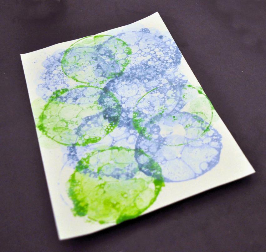 A paper with blue and green bubble prints on it.