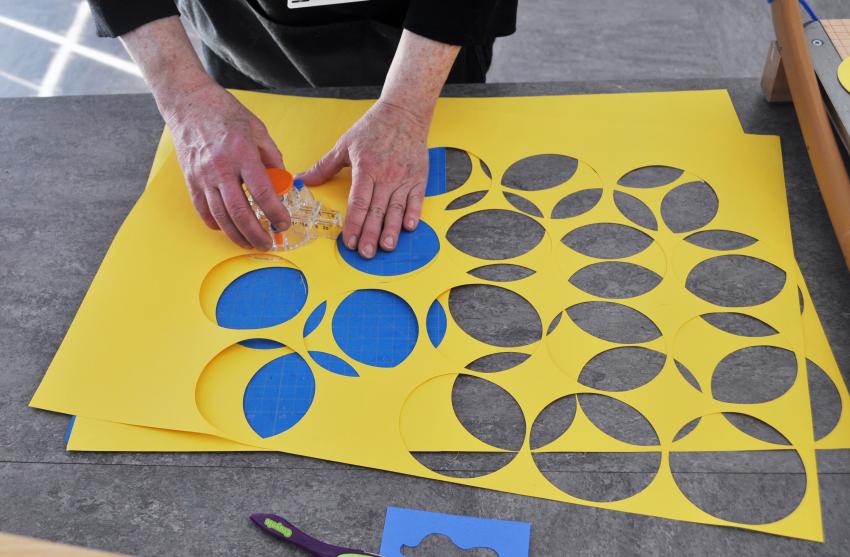 A team member cutting out yellow paper circles.