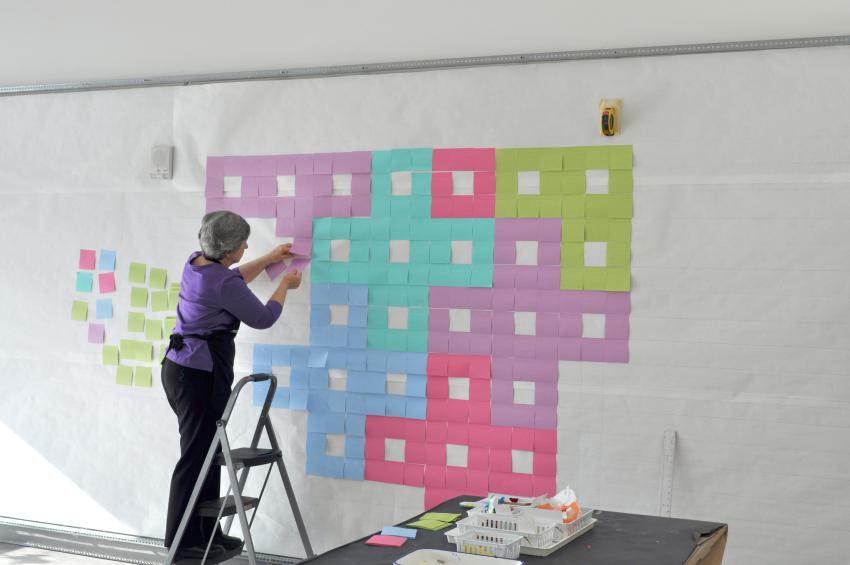  A volunteer installing Post-Its onto the display wall. 