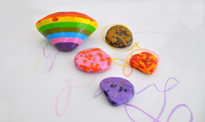 Colorful rainbow and rock crayons on top of scribbles.