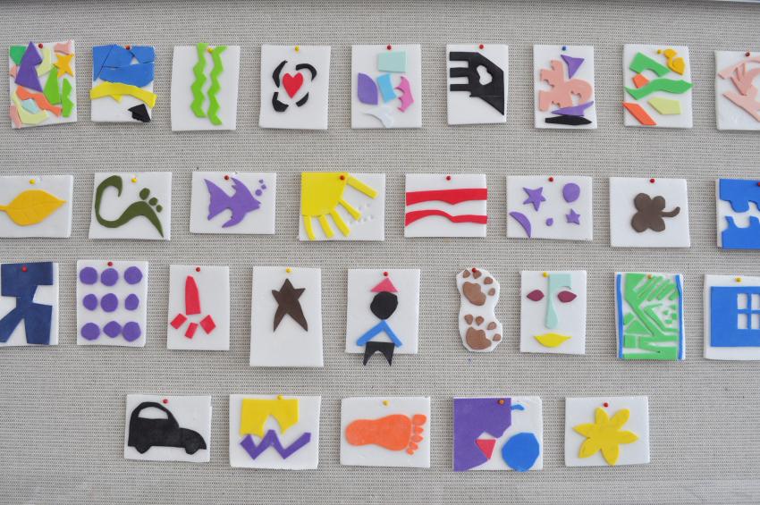 40 handmade stamps displayed on a wall.
