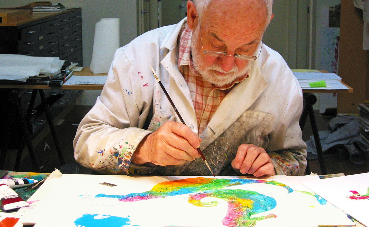 Eric Carle sitting at table painting seahorses