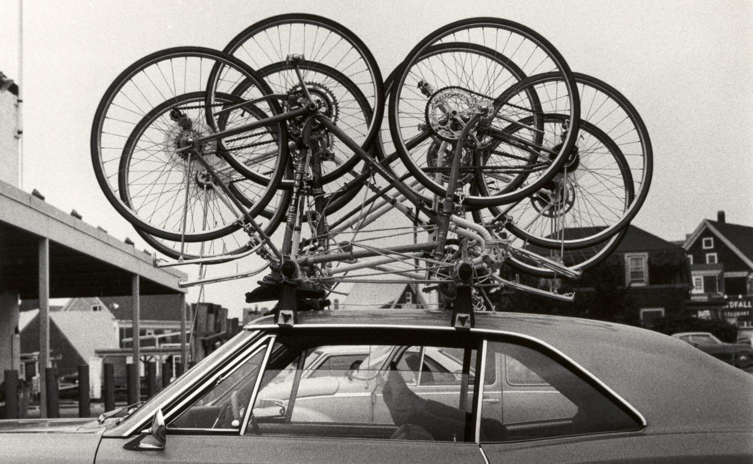 Photograph of bicycles on roof of car. 