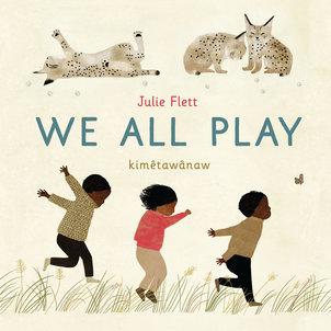 Cover image for We All Play shows three children bounding playfully through grass while above them three small wild cats roll and play with each other.