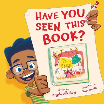 A child wearing glasses and a striped shirt holds up a hand drawn flier looking for his lost book.