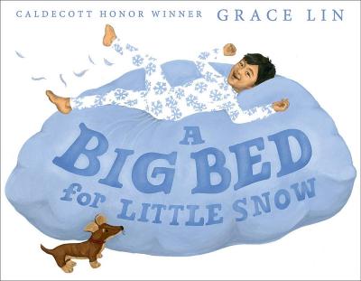 A boy in snowflake pajamas smiles while jumping onto a fluffy bed of snow.