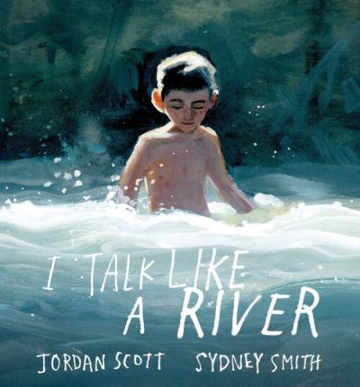 A shirtless boy wades into the small rapids of the river.