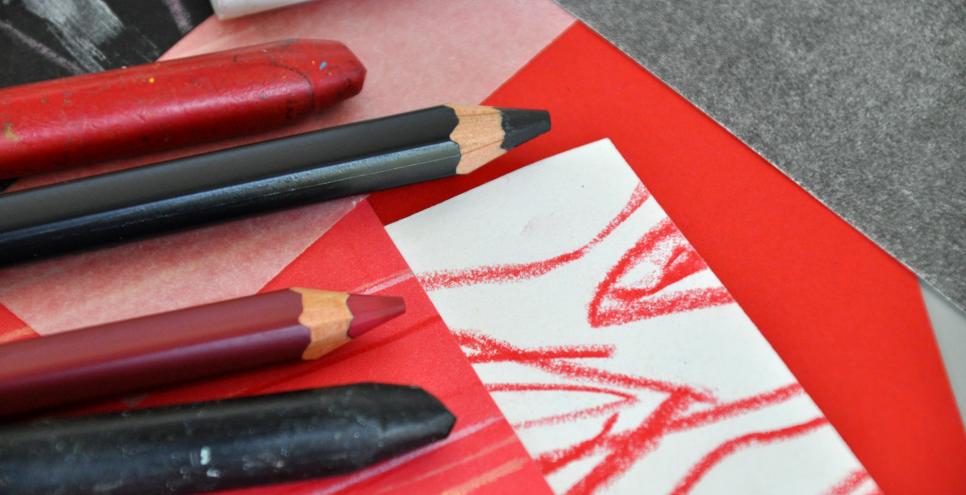 Black, red, and white papers and drawing tools