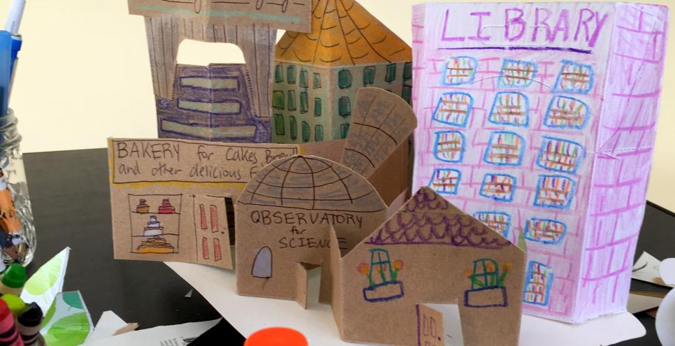 A town constructed out of cardboard and drawing tools.