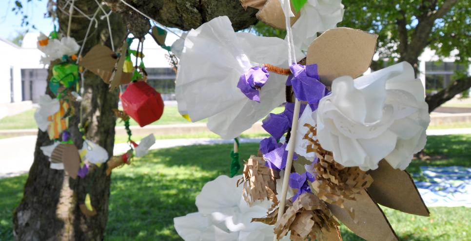 A grouping of found material mobiles attached to an apple tree outside the museum.