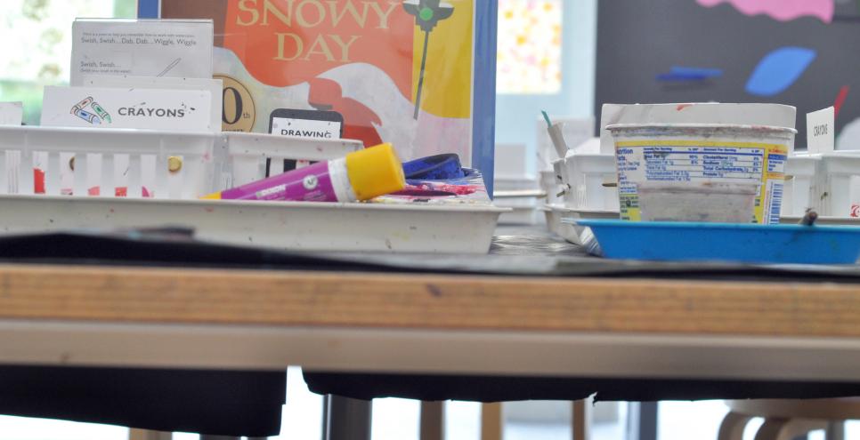 A toddler's height view of an Art Studio table with books and art supplies.