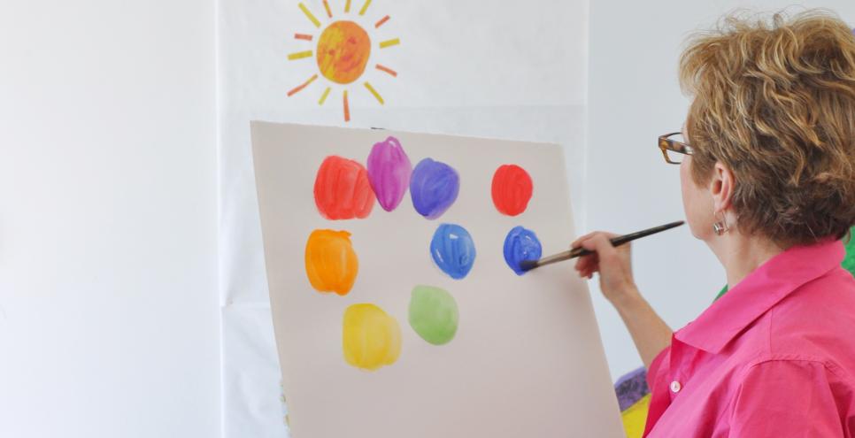 Author/illustrator Melissa Sweet painting a color wheel on an easel in the Art Studio.