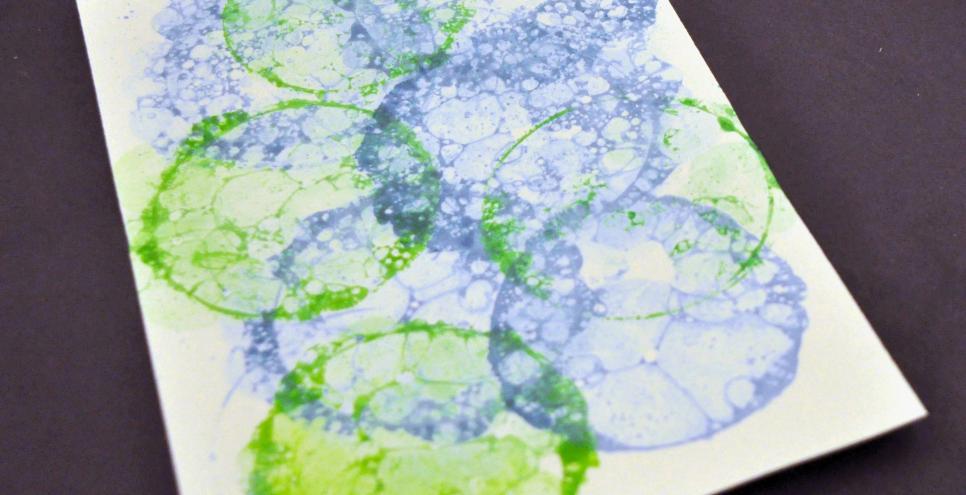 A paper with blue and green bubble prints on it.