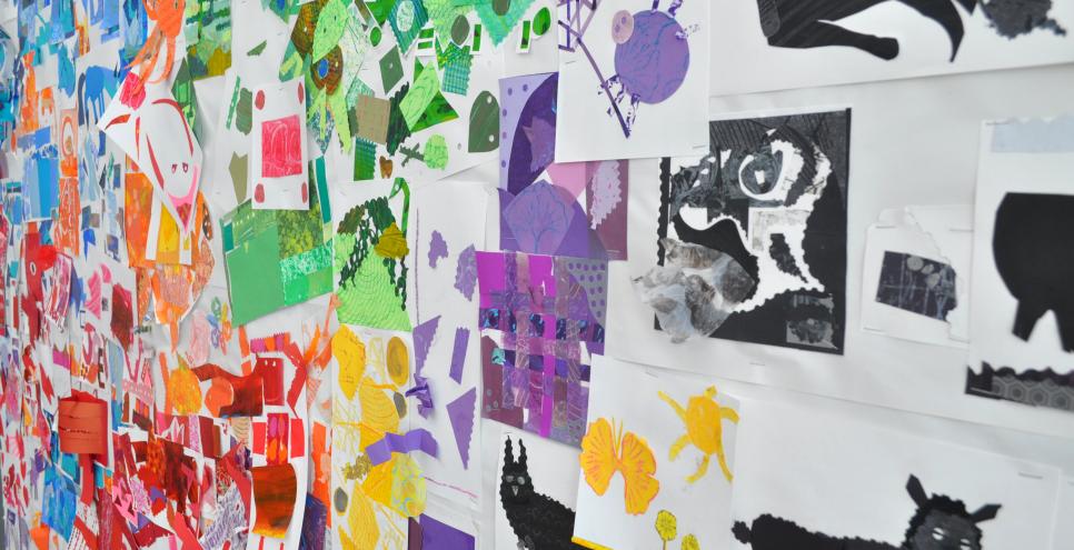A wall filled with colorful, handmade collages.