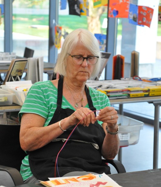 Participant focusing on shaping the wire into a word.