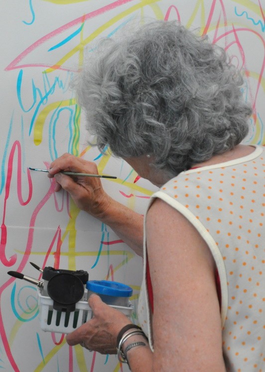 Close-up of a participant painting on the wall, using their wrist joint.