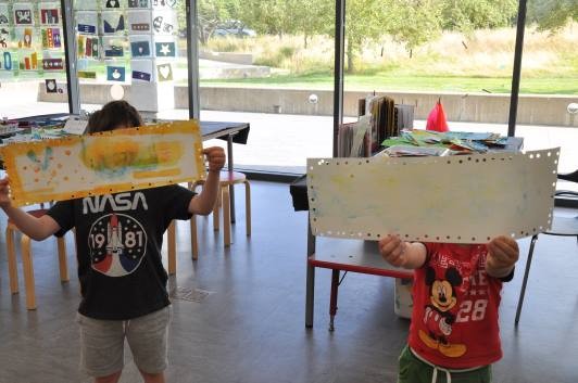 Guests in the Art Studio holding up their artwork