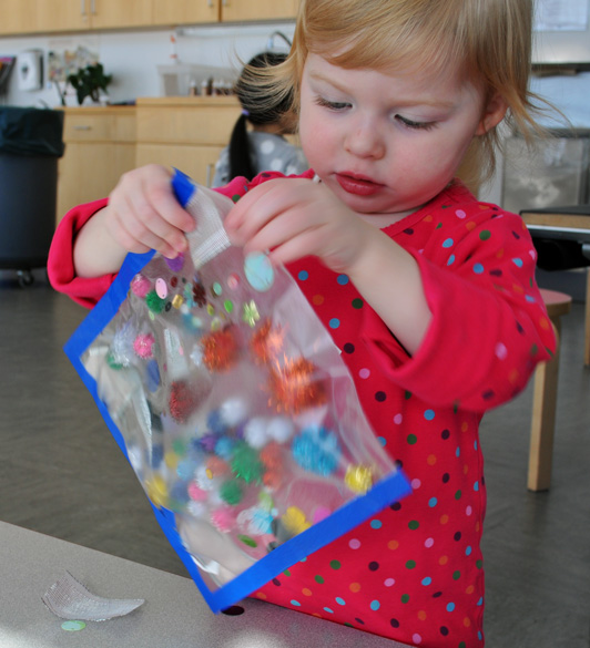 toddler examining her contact paper pocket 