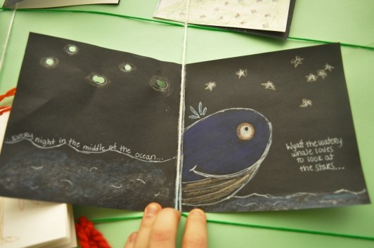 A book where a guest used colored pencils to draw and ocean and a whale with the description “Every night in the middle of the ocean…Wyatt the watery whale loves to look at the stars…”