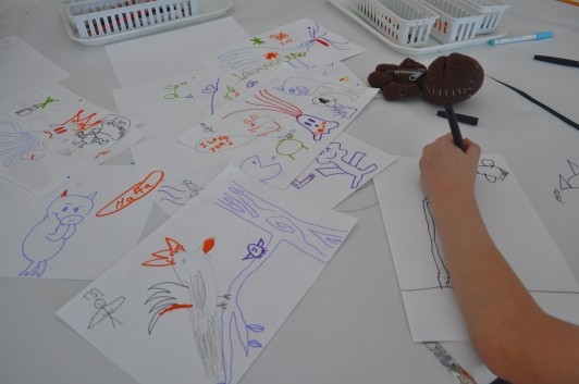 A guest participates in the doodle game by adding lines to an existing scribble to make a picture.